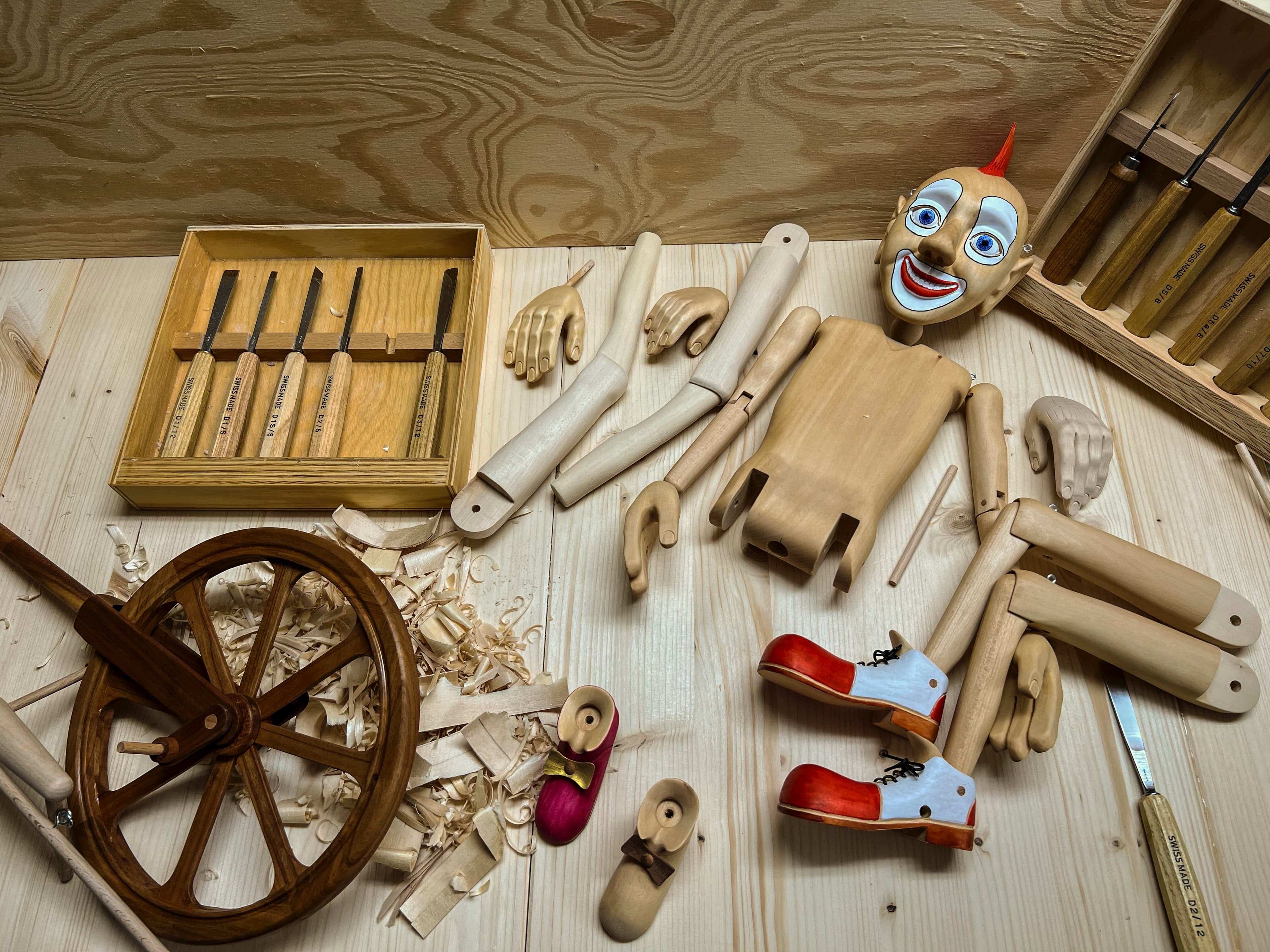 Assembly of a monocycle clown marionette in a workshop.